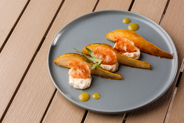 Grilled tiger shrimps with honey rear and cream cheese. Grilled seafood. On wooden background.