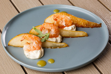 Grilled tiger shrimps with honey rear and cream cheese. Grilled seafood. On wooden background.