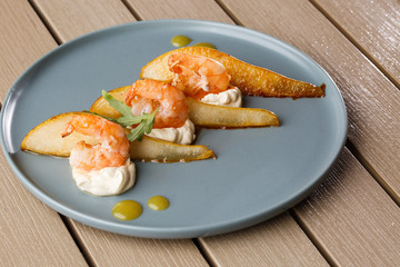 Grilled tiger shrimps with honey rear and cream cheese. Grilled seafood. On wooden background.