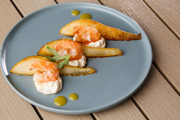 Grilled tiger shrimps with honey rear and cream cheese. Grilled seafood. On wooden background.