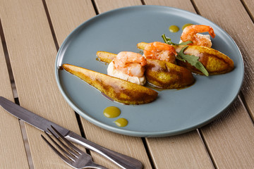 Grilled tiger shrimps with honey rear and cream cheese. Grilled seafood. On wooden background.