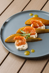 Grilled tiger shrimps with honey rear and cream cheese. Grilled seafood. On wooden background.