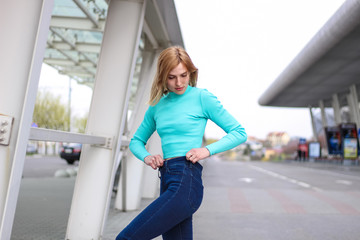 The girl is blonde in a blue croptop. Street clothing. Sport. Advertising. Fashion and style. Copyspace. Mockup