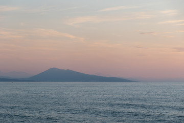 Naklejka na ściany i meble Wunderschöner Sonnenuntergang: Im Hintergrund ein großer Berg, der in den Atlantik hineinragt.