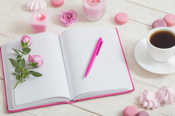 notebook with cup of coffee on white wooden table
