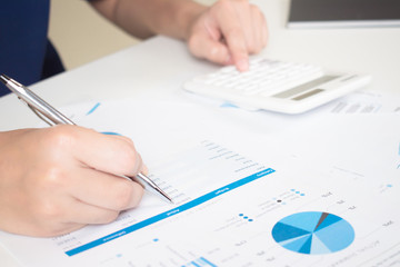 The accountant is checking the work and calculating the expense data in the graph to make money at work.