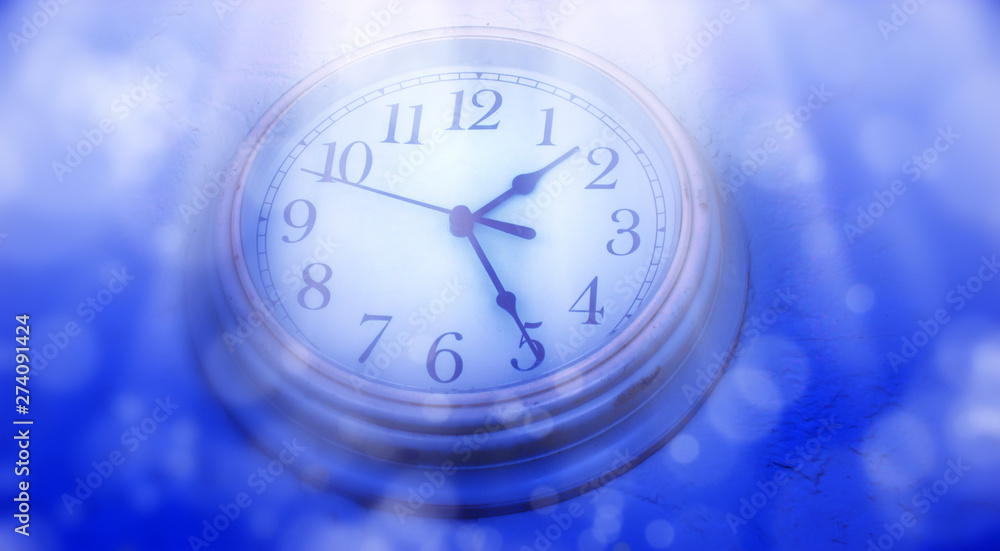 Poster abstract defocused lights and close up clock face over blue background