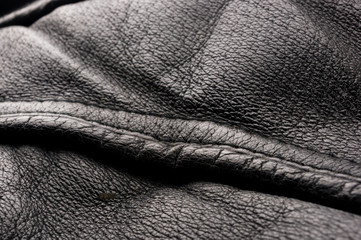 Old vintage genuine soft black leather texture background, top layer with pores and scratches,...