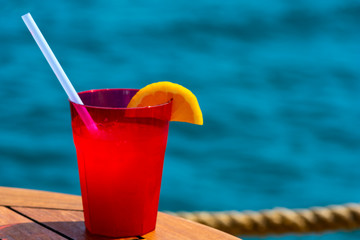 Fruit cocktail on wood with blur sea background. Travel and relax concept