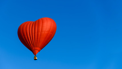 Naklejka premium balloon heart on blue sky background symbol of love and romance