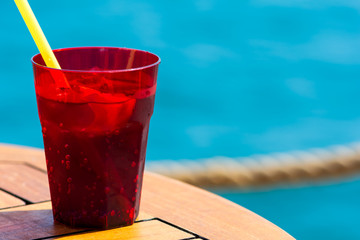 Fruit cocktail on wood with blur sea background. Travel and relax concept
