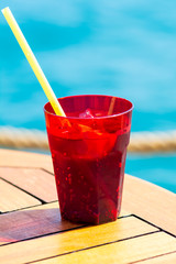 Fruit cocktail on wood with blur sea background. Travel and relax concept