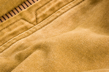 clothing items stonewashed cotton fabric texture with seams, clasps, buttons and rivets, macro