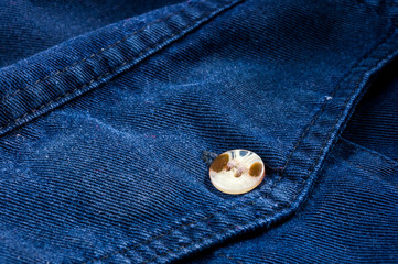 clothing items stonewashed cotton fabric texture with seams, clasps, buttons and rivets, macro
