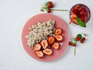 oatmeal with strawberries and strawberry lemonade on the white table