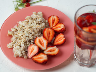 oatmeal with strawberries and strawberry lemonade on the white table