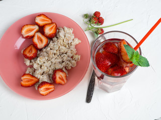 oatmeal with strawberries and strawberry lemonade on the white table