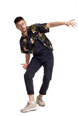 Full-length portrait of a funny guy dancing in studio isolated on white background.