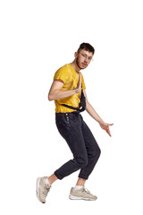 Full-length portrait of a funny guy dancing in studio isolated on white background.