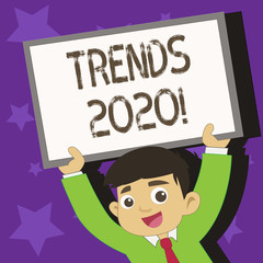 Conceptual hand writing showing Trends 2020. Concept meaning general direction in which something is developing next year Young Student Raising Upward Frame Whiteboard Above his Head