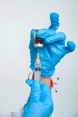 Woman doctor fills syringe with medicine. Procedures in the medical office. Nurse's hands in blue...