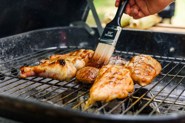 Roasted chicken drum stick, chest and sirloin beef with barbecue sauce on stove