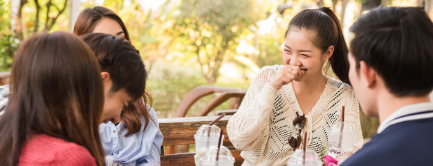 Group of six teenagers having fun together in coffee shop on the afternoon