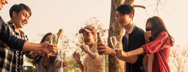 Obraz premium Hands of man in group of friends opening champange for celebrate, cropped dimension for banner
