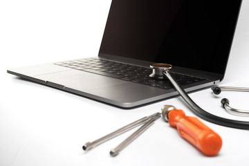 Laptop service concept with tools and stethoscope