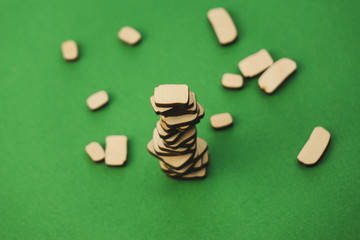 a pile of wooden stones and one big building on a green background