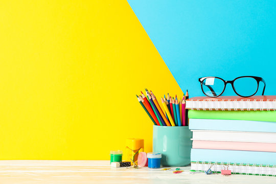 School supplies on wooden table against color background, space for text