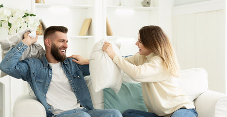 Loving Couple Having Fun Fighting Pillows And Enjoying Time Together