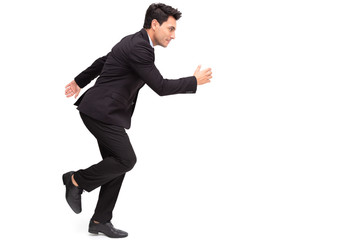 Handsome Caucasian businessman in formal suit is running isolated over white background