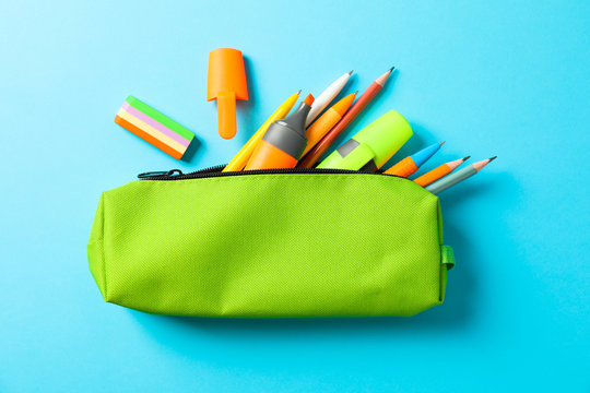 Pencil case with school supplies on blue background, space for text
