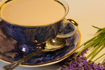 Cocoa with milk in a pearl blue mug and lavender flowers