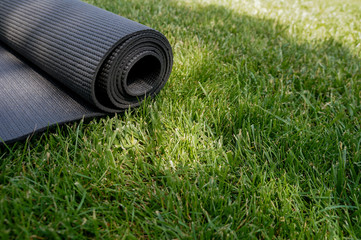 Yoga mat on a grass background. Equipment for yoga. Concept healthy lifestyle. Lots of copyspace