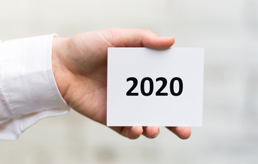 Woman hand holding white card with black text