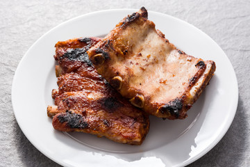 Grilled barbecue ribs on gray stone background