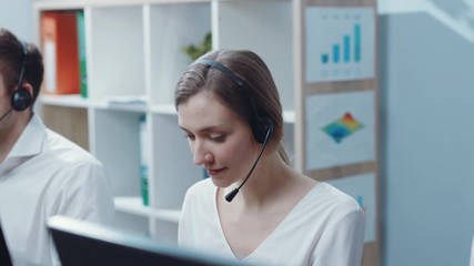 Smiling millennial female telemarketer operator wearing headset talk consulting clients online using pc, positive woman call center agent speak working as customer service representative on helpline