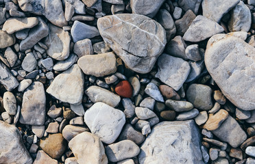  river stones on the beach with a pebble in the form of a heart