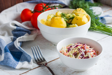 homemade coleslaw salad boiled potato with dill  fork napkin on wooden table