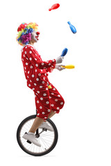 Clown on a unicycle juggling with clubs