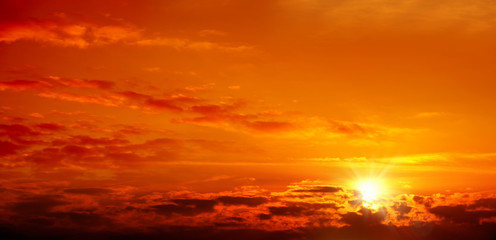 Naklejka na ściany i meble Beautiful cloudscape of orange colored sunset sky with shining sun