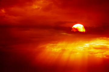 Beautiful cloudscape of orange colored sunset sky with shining sun