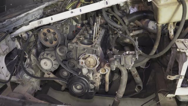Old car with disassembled engine under the hood