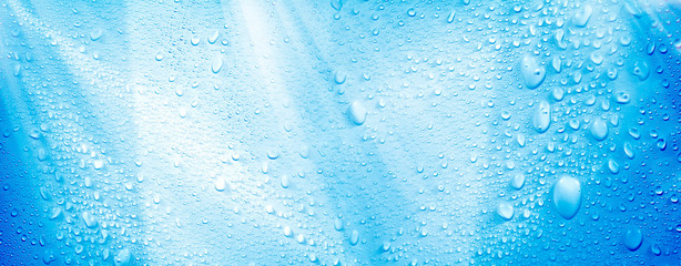 Abstract background image of close up shiny raindrops on blue surface