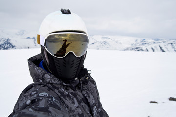 Fototapeta na wymiar snowboarder on the slope of the ski slope takes a selfie on the camera