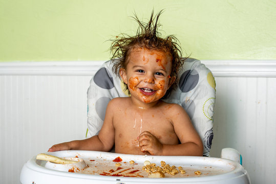 A little boy making a mess while eating