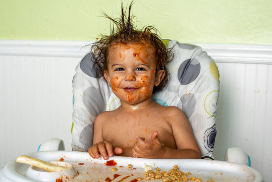 A little boy making a mess while eating