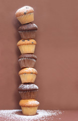 tower built with muffins in front of a brown background